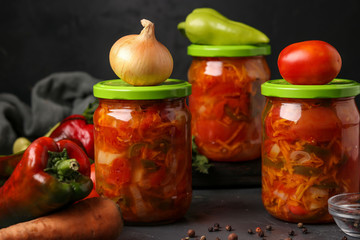Vegetable salad in jars for the winter of tomatoes, carrots, onions and peppers, horizontal arrangement
