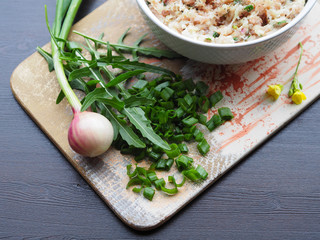 Green onions, spicy herb arugula, raw minced meat in a plate on the original Board. Delicious and simple recipe for juicy filling for hamburgers, cutlets, pies, rolls, pita, casserole, burger, chop.