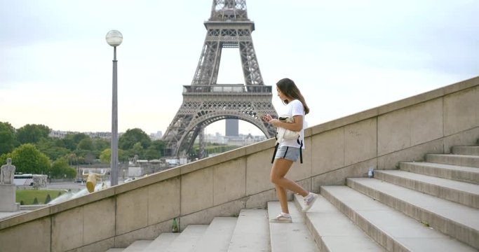 lady with phone goes down stairs at Eiffel Tower slow motion