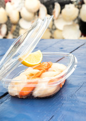fresh raw scallops in a plastic box for take away