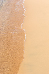 Wave of the sea on the sandy beach.