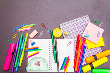 Back to school concept. School education supplies on black stone concrete background.