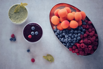Fruit and berry smoothies and green smoothie. Top view. Gray background.