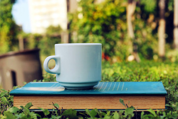 Cup of coffee and a book in the forest.