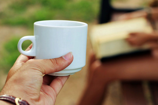 Person Picking Up A Cup Of Coffee.