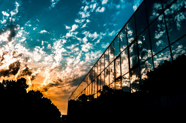 Tramonto in città con piccole nuvole bianche e il sole infuocato