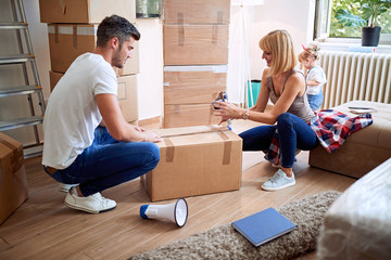 Happy family unpack boxes moving to new home.