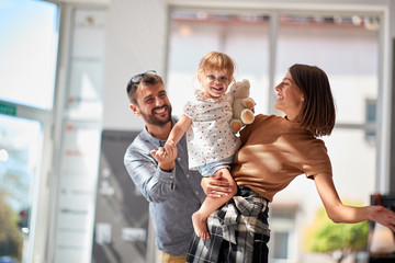 man and woman with smiling child girl in store shopping.