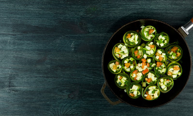 Zucchini in the background. Fried young sliced courgettes in a pan on a dark background. The view from the top. Copy space