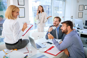 Group of business people working and communicating together in creative office.