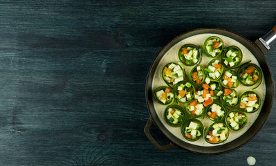 Zucchini in the background. Fried young sliced courgettes in a pan on a dark background. The view from the top. Copy space