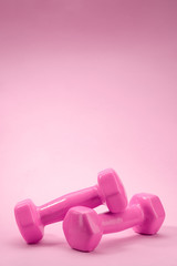 Dumbbells on pink background