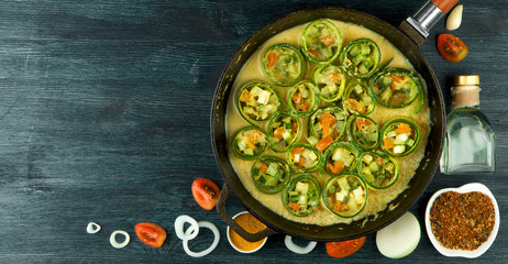 Zucchini in the background. Fried young sliced courgettes in a pan on a dark background. The view from the top. Copy space