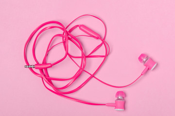 In-ear headphones on pink background