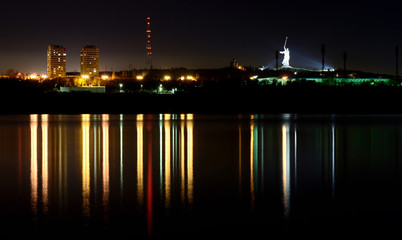 Fototapeta na wymiar Reflection of a night city in a calm river.