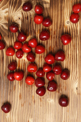 Fototapeta na wymiar Red sweet cherry scattered on a wooden table