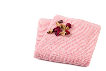pink towel with dry flowers rolled out isolated on white background