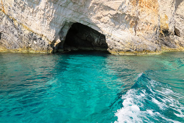 Entrance of cave in clear azure blue sea