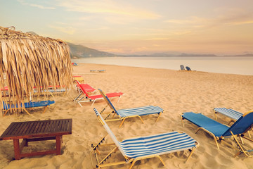 Colorful sunbeds on sandy beach and sea