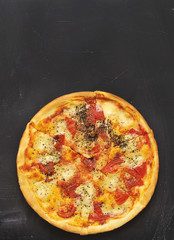 Delicious pizza on dark board.