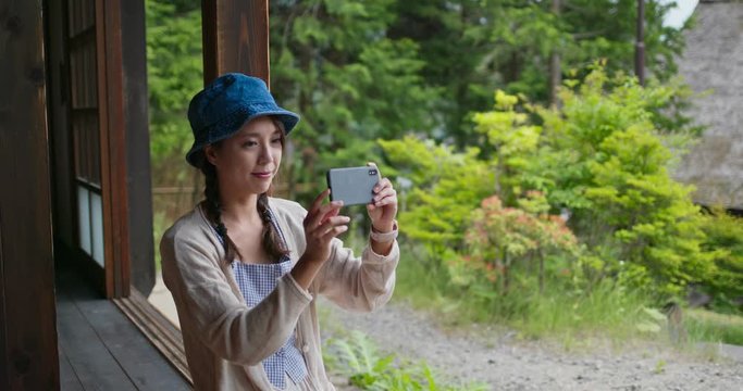 Woman take photo with cellphone in Japanese old village wooden house