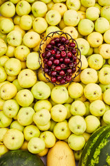 Yellow ripe apples, pile of fresh apple fruits, basket with cherries