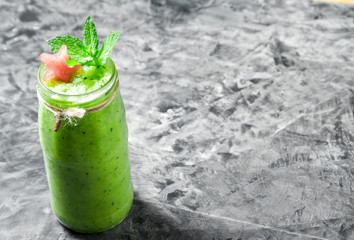 Tropical cocktail. Smoothie with mint, slices of watermelon and ice cubes on a gray concrete surface. View from above. Copy space