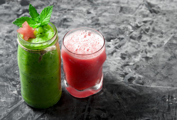 Tropical cocktail. Smoothie with mint, slices of watermelon and ice cubes on a gray concrete surface. View from above. Copy space