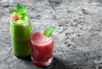 Tropical cocktail. Smoothie with mint, slices of watermelon and ice cubes on a gray concrete surface. View from above. Copy space