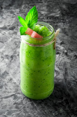 Tropical cocktail. Smoothie with mint, slices of watermelon and ice cubes on a gray concrete surface. View from above.