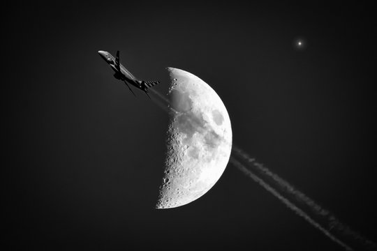 Airplane flying by the moon and star in the night sky - Powered by Adobe