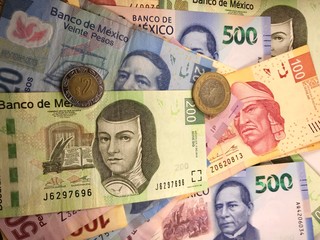 Mexican peso bills spread randomly over a flat surface