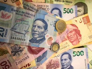 Mexican peso bills spread randomly over a flat surface