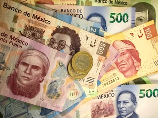 Mexican peso bills spread randomly over a flat surface