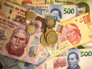 Mexican peso bills spread randomly over a flat surface