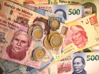 Mexican peso bills spread randomly over a flat surface