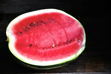 Fototapeta na wymiar A watermelon cut in half, on an old rustic table.