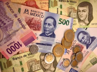 Mexican peso bills spread randomly over a flat surface