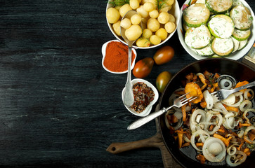 Vegetables on the background. Fried zucchini sauce in a plate. Young boiled potatoes with dill in a bowl. Fried chanterelle mushrooms with golden onions in a frying pan. copy space