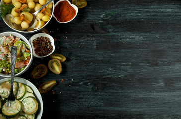 Vegetables on the background. Fried zucchini sauce in a plate. Young boiled potatoes with dill in a bowl. Fried chanterelle mushrooms with golden onions in a frying pan. copy space