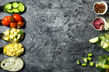 Vegetables on the background. Fresh vegetables (cucumbers, tomatoes, onions, garlic, dill, green beans) on a gray background. Top view. Copy space