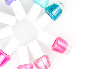 Group of few bright pink blue nail polishes composing a circle on the white background. Top view
