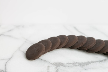 Sleeve of thin mints cookies on white marble background, chocolate mint thin round cookies