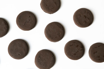 Group of thin mints cookies on white background, chocolate mint thin round cookies, top view