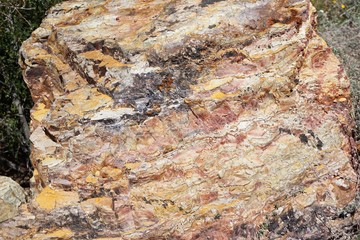 Colorful natural rough stone surface with variegated pattern