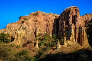 Earth Forest of Yuanmou in Yunnan Province, China - Exotic earth and sandstone formations glowing in the sunlight. Naturally formed pillars of rock and clay with unique erosion patterns. China Travel