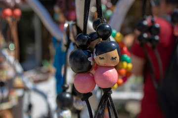 Keychains made of wooden beads. On the beads is a picture of a slanted lady in the Asian region.