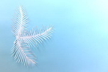 Romantic dreamy background with paper spiky leaves on bright blue background with copy blank space.