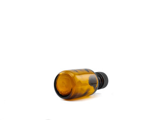 Backside of a small empty amber pharmaceutical glass bottle with black plastic cap for aromatherapy or mockup on white background