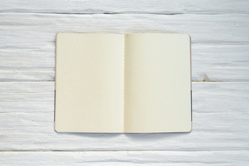 Blank page open book with copy space on a white wooden table background.